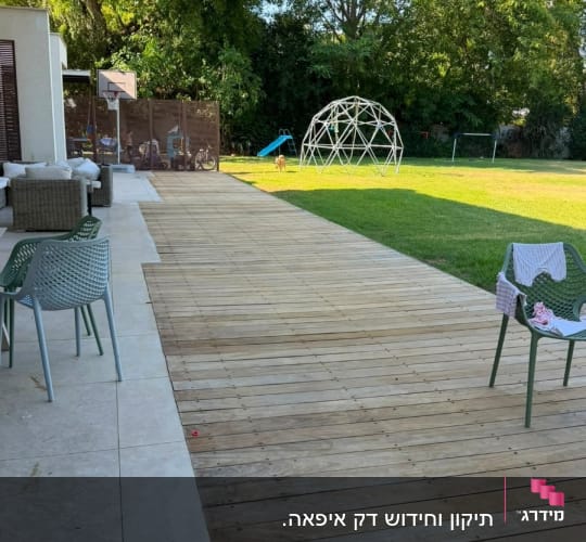חצר עם דק עץ, כיסאות ומשחקים לילדים